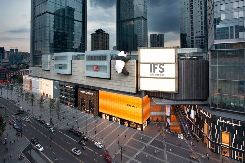 Chengdu IFS International Finance Square at dusk with the iconic climbing panda sculpture, surrounded by luxury retail stores and modern skyscrapers in Jinjiang District — China Mobile operates service halls throughout central Chengdu
