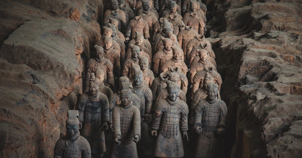 Rows of Terracotta Army warriors standing in an excavated earth pit in Lintong, Xi'an, with the front rank of soldiers in the foreground